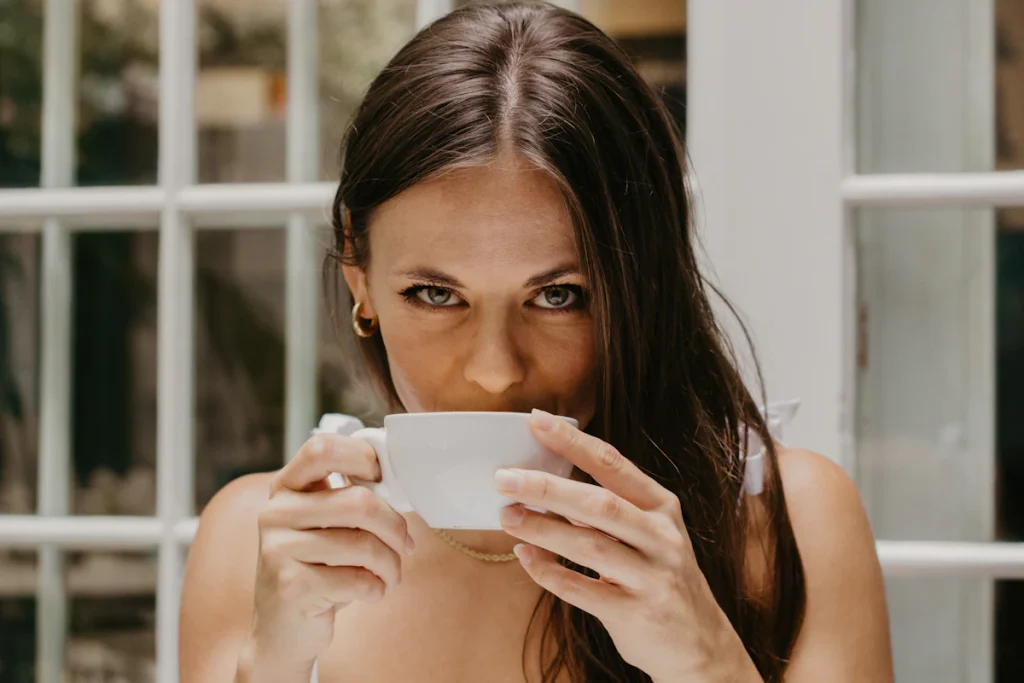 Mujer con una taza junto a la ventana, en un momento de calma tras una ruptura