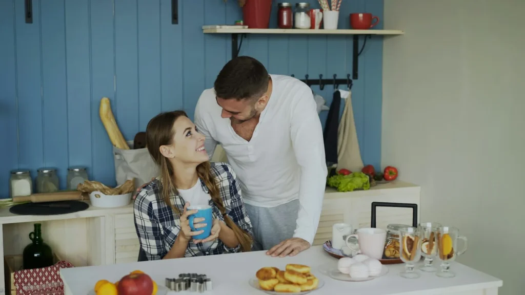 Pareja conversando con calma en la mesa de la cocina con un café